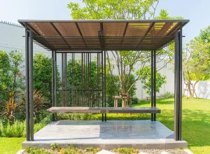 Backyard pergola over a paved patio and lawn area
